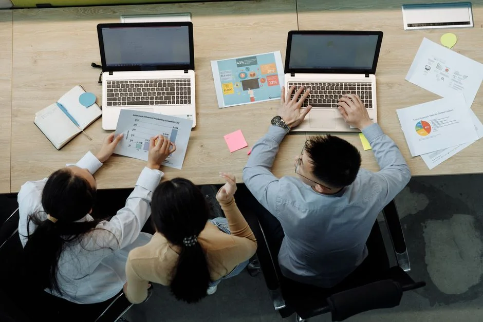 A modern office setup featuring a laptop and a whiteboard schedule for social media platforms.